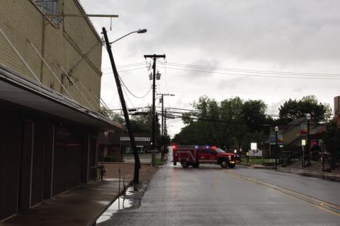A splintered utility pole rested on the awning of the Canton Herald building on the Buffalo Street side downtown mid-morning April 20 during heavy rain and high wind. Electricity was cut off in the area while work crews replaced the utility pole. No one was injured. Photo by David Barber